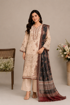A woman models a traditional three-piece salwar kameez suit in a studio setting. The set features a beige embroidered kurta, matching beige trousers, and a dark navy dupatta with intricate red and gold border patterns.