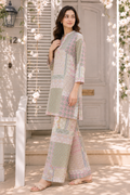 A woman models a light pastel patchwork kurta and wide-leg pant set with floral prints, standing on a sunlit porch with white shutters and hanging flowers.